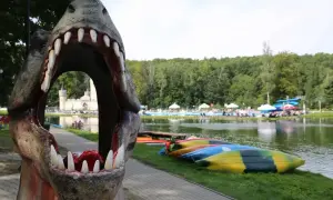 Przez paszczę dinozaura widać zamek i basen. To jedne z magicznych miejsc opolskich, gdzie czeka wodna zabawa i kajaki.
