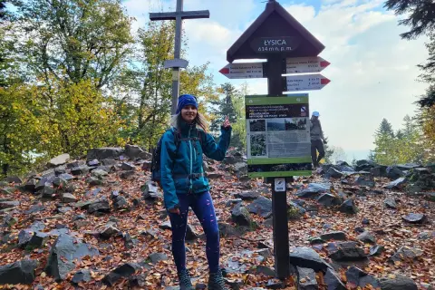 Kobieta na szczycie Łysica, 614 m n.p.m., przy drogowskazie. Jesienny szlak, liście i kamienie.
