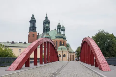 Czerwony most na Ostrowie Tumskim w Poznaniu, idealny na spacer i odkrywanie poznańskich atrakcji dla dorosłych. W tle katedra.