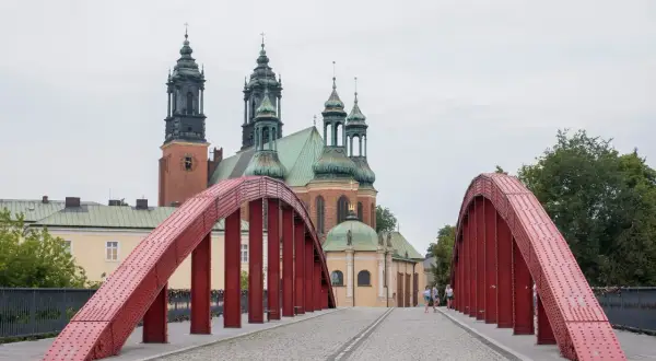 Czerwony most na Ostrowie Tumskim w Poznaniu, idealny na spacer i odkrywanie poznańskich atrakcji dla dorosłych. W tle katedra.